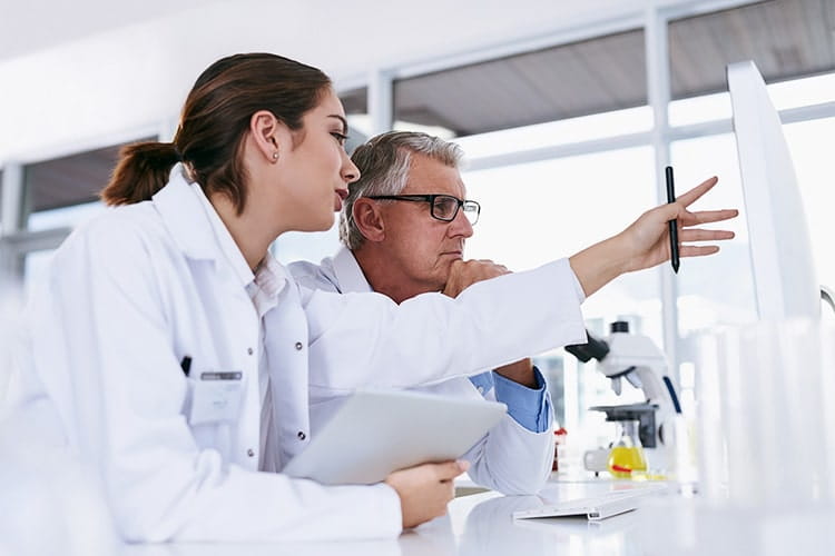 Shot of two scientists working together on a computer in a lab.